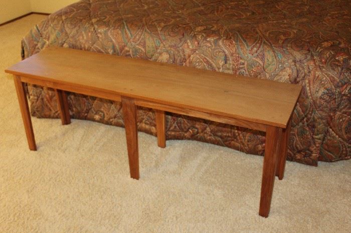 Solid wood bench, pictured at the end of a kind size bed