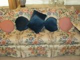 Floral upholstered sofa with throw pillows.