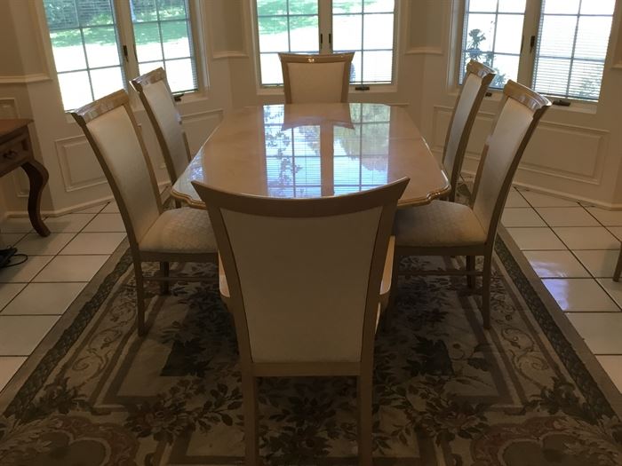 Formal dining room table with 8 uphostered chairs. This table has a marble look top.