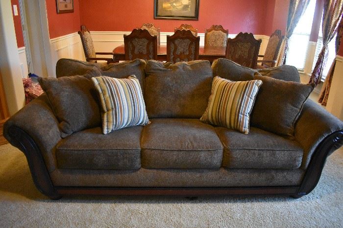 Taupe traditional sofa w/attached back pillows.