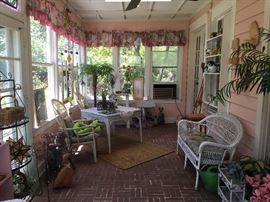 Bamboo chairs, wicker dining table, plant stands, wind chimes. 