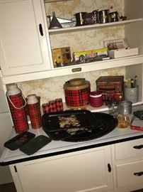 Variety of vintage trays and plaid thermoses and lunch boxes.