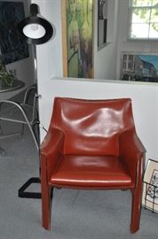 Amazing mid century burnt red leather arm chair by Cassina made in Italy  26.5"w x 30'h  x 23"d shown with a fabulous mid century chrome and black adjustable floor lamp