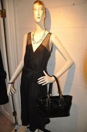 Our "Sabrina" showing off a black wrap dress, a great necklace and a black patent leather Coach handbag