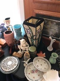 a stained glass lamp in the den with vintage pottery