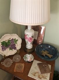 lots of collectibles and decorative accessories in the living room. Fostoria. Painted plates. Floral lamps. Crosses. 