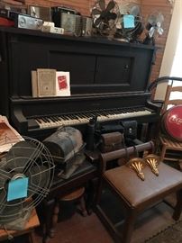 Antique upright piano and old fans