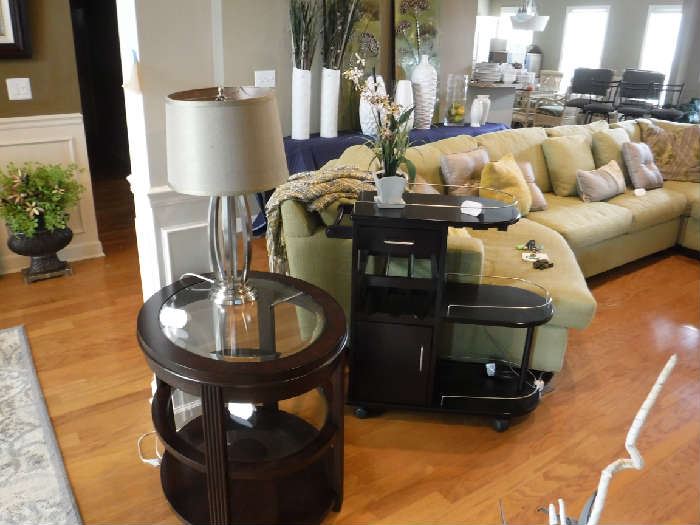 What a sectional! The end table has a twin and there is also another in an oval shape of the same style. The black item is a small portable bar on wheels.
