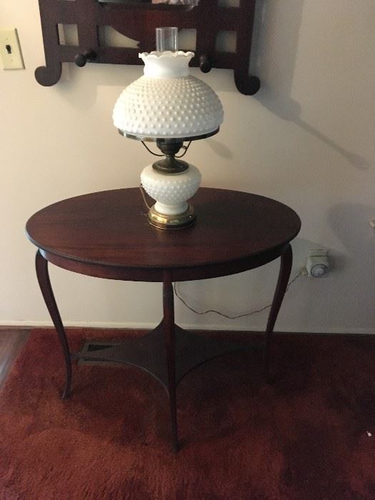 a beautiful lamp table with milk glass hurricane-style lamp