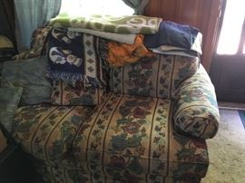 A nice love seat with an assortment of throws.