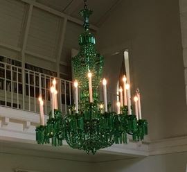 An immense emerald green glass chandelier with 18 lights, 12 on bottom ring, 6 on upper ring, drops and strands hung off bronze or brass plates and rings, purchased from and originally installed by Nesle c. 1960.