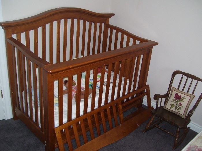 The baby will sleep well  in this crib while their sibling rocks and watches.