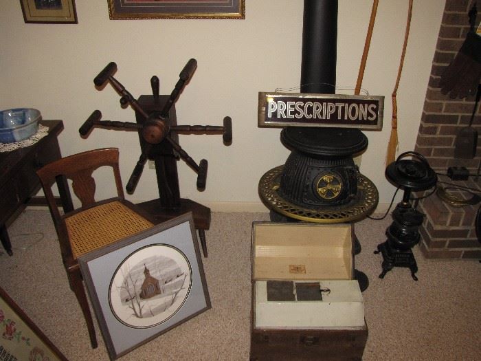 One of two Spinning wheels, cast iron stove, antique glass Prescription sign. 