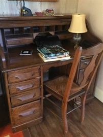 Vintage roll top desk shown with one of the cane dining room chairs