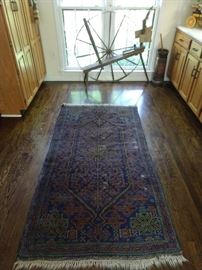 Hand woven Turkish tribal rug, 100% wool, measures 3'8" x 7' 2". Vintage wooden spinning wheel and butter churn in the background.