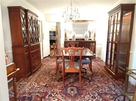 View of the dining room, with banded mahogany dining table (it has two matching banded leaves) set of four Henredon Chippendale style side chairs, 1940's flame mahogany breakfront cabinet, with bubble glass, vintage lighted 5-glass shelf curio cabinet, all atop a FABBY Persian Heriz!