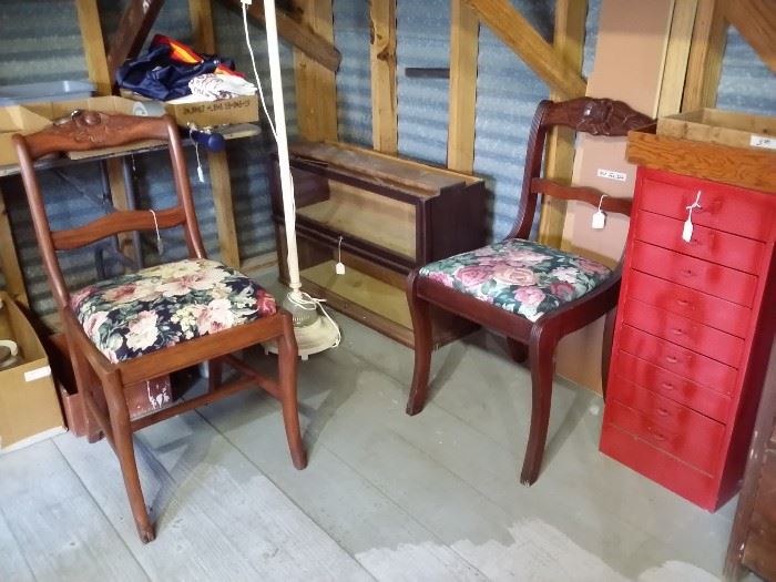 Two vintage chairs, in the corner are two shelves that for a barrister bookcase