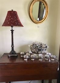 Drop leaf walnut table supporting a silverplated punch bowl with 36 matching cups - not sure we've ever seen that many plated ones before!