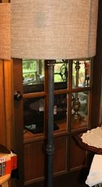 Metal floor lamp in den with burlap shade.