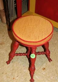 Piano stool painted red.