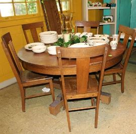 Round oak table with large pedestal and chairs.