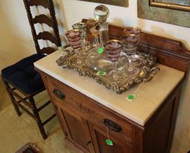 Another oak chest with marble top, silver tray, wine bottle and beautiful wine glasses.