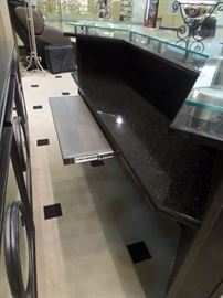 This is a 2 piece bar with granite counters and complete rear hutch/display. It has storage and a pull out shelf with cabinet doors front and back.