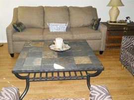sofa, metal and tile coffee table, rope lamp, vintage trunk, etc.