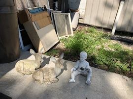 cement lawn ornaments of deer and boy. windows in background