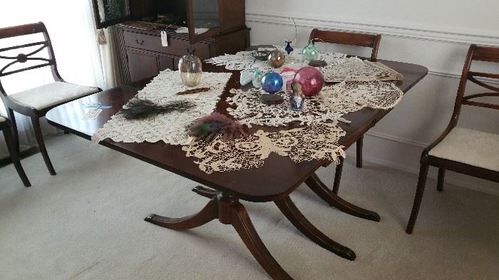 mahogany drop leaf dining table with 3 extra leaves and pads.....set of 4 dining chairs, priced separately.  vintage lace doilies...hand blown glass ornaments