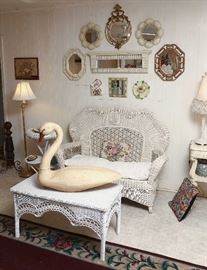 Wicker loveseat and low table.  Swan decoy is signed. Collage of small mirrors and plates.