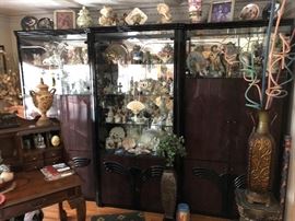 large lacqured glass cabinet full of figurines from the 50's and on. Barware and serving pieces