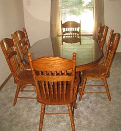 Glass covered dining table with 6 chairs