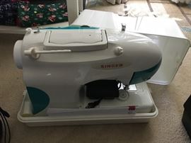 Singer sewing machine with hard sided carrying case.