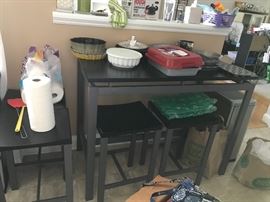 Long high top table with 4 backless stools. Various kitchen items and bakewear.