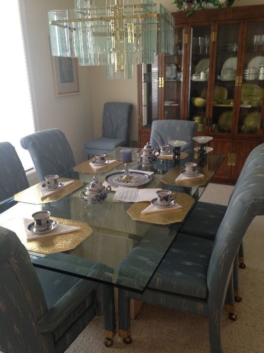 Contemporary polished travertine marble base and glass top dining table; 8 chairs.