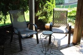 Two patio chairs and a metal table