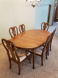 Exquisite dining room table with 6 chairs and leaves.