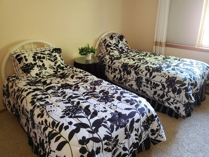 Two twin beds with headboards and bedding.  Small nightstand table.
