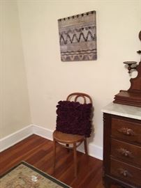 Chair, accent pillow, wall hanging