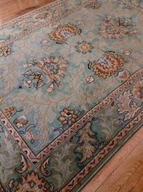 Muted blue and gold colors are in this area rug