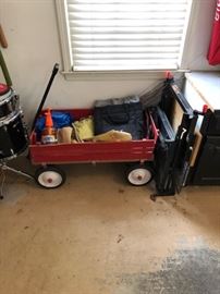 Red wagon full of garage items and tools.