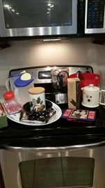 2 matching plastic pitchers, smaller-size food processor, cute polka dot serving bowl, electric kettle with cord, Pampered Chef tube pan-NIB, trivets, small canister. 