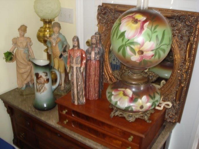 gold mirror,  porcelain figurines, wooden carved figurines, gone with wind table lamp, walnut marble top chest.