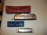 Two vintage Hohner harmonicas with cases.