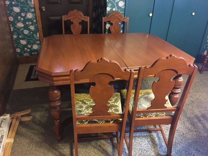 Antique table with 2 leaves for expansion. Five matching chairs.
