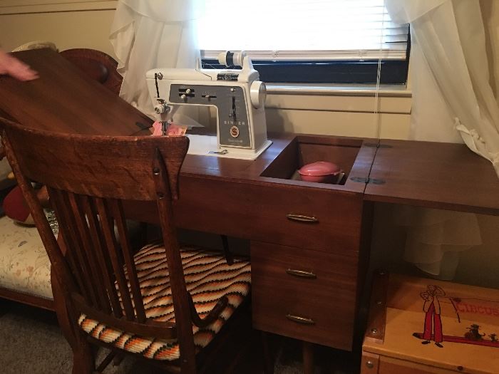 Singer sewing machine in desk with matching chair.