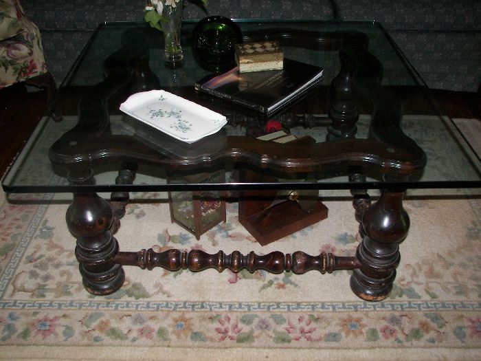 thick glass top coffee table with dark wood base and rug