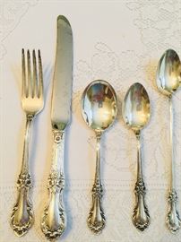 close up of place setting for 12 sterling flatware with no monograms