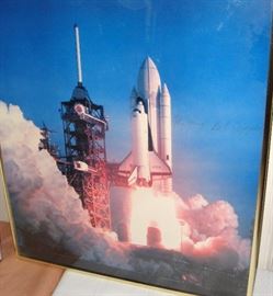 COLUMBIA CARRIED A CREW OF TWO. THIS IS A FRAMED PICTURE OF THE COLUMBIA SPACE SHUTTLE WITH TWO SIGNATURES - JOHN YOUNG, COMMANDER and ROBERT CRIPPEN, PILOT.